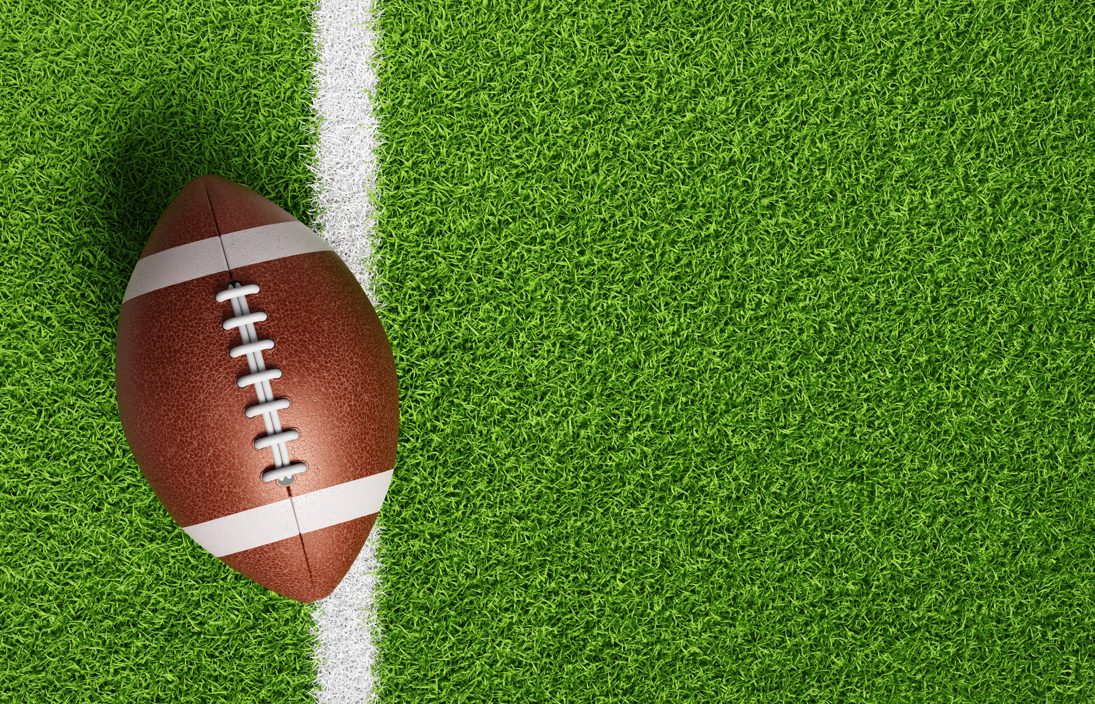 American football ball on green grass. 3d-rendering